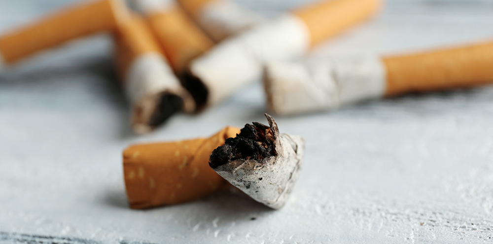 Cigarette butts on wooden background