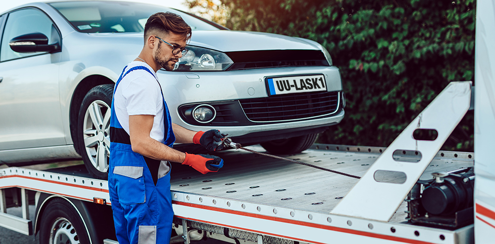 Handsome middle age man working in towing service on the road. Roadside assistance concept.